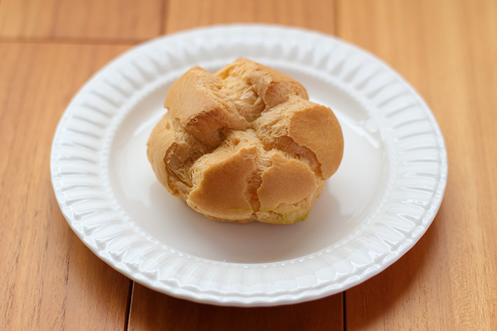 A cream puff and a plate taken with natural light